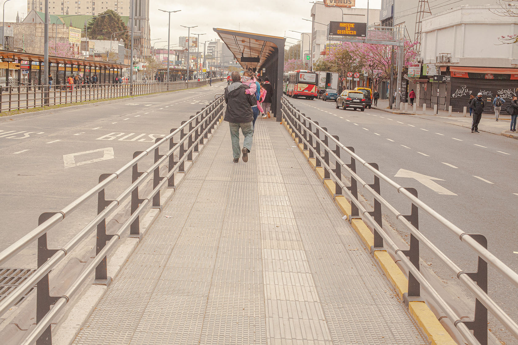 Pedestrians walking on central crossing island on large avenue
